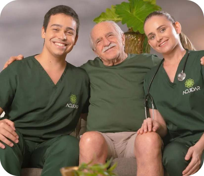 Cuidadores da Acuidar Pouso Alegre ao lado de um idoso sorrindo